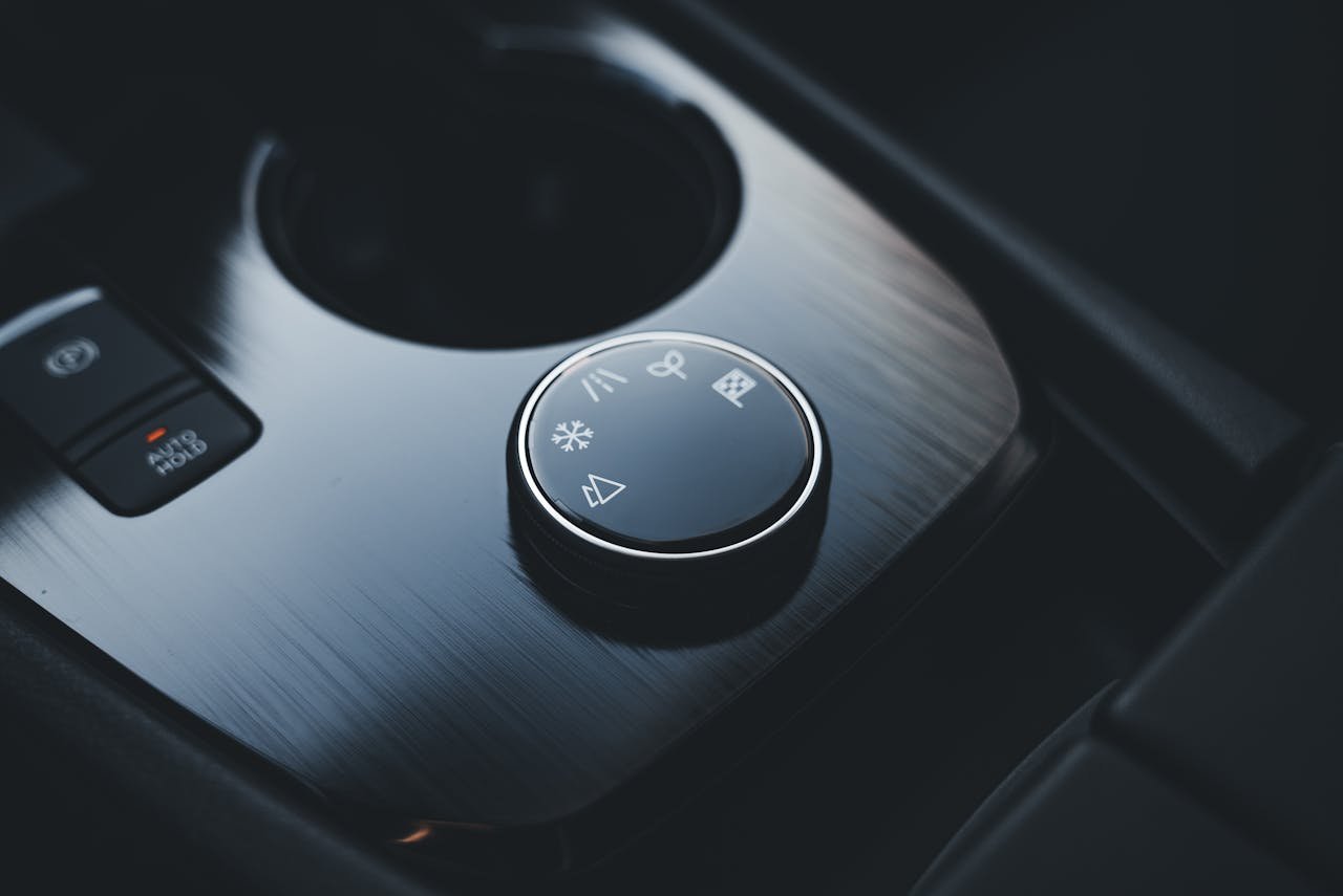 Home Detailed view of an SUV's sleek and modern center console dial for driving modes.